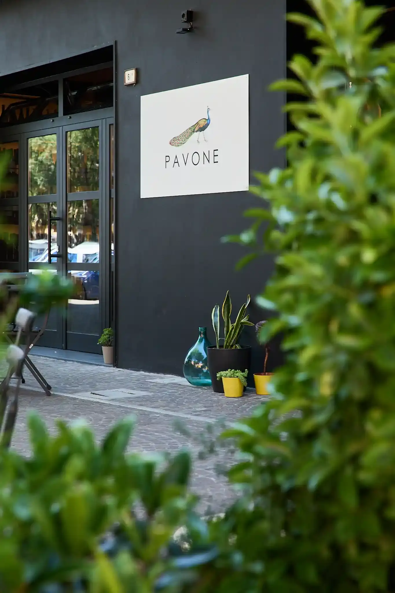 L'ingresso dell'enoteca con l'insegna del Pavone, visto dal dehors
